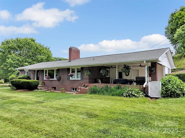 463 Golf Course Rd, Clyde, NC 28721 - view of front of house with a ceiling fan, a front yard, a chimney, and brick siding