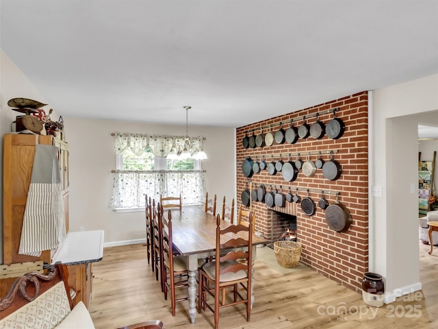 463 Golf Course Rd, Clyde, NC 28721 - dining area with wood finished floors, a fireplace, and a chandelier