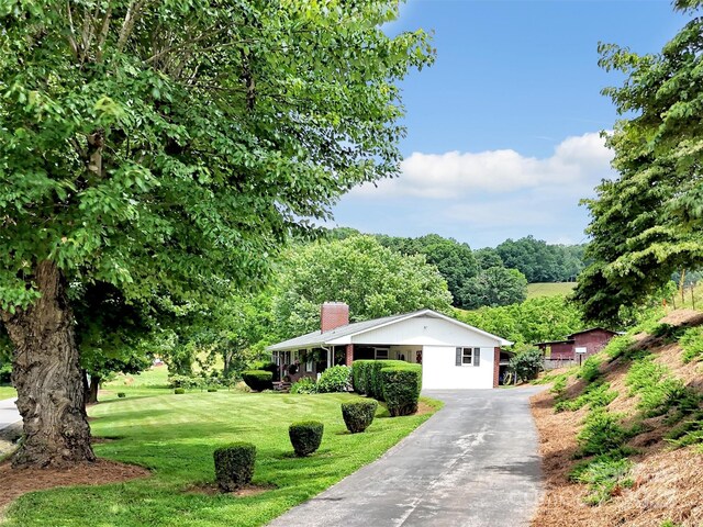 463 Golf Course Rd, Clyde, NC 28721 - single story home with a chimney, a front yard, and asphalt driveway