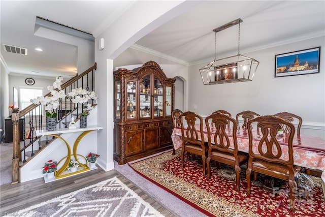 2110 Owls View Ln, Colfax, NC 27235 - dining area featuring a chandelier, stairway, wood finished floors, ornamental molding, and arched walkways