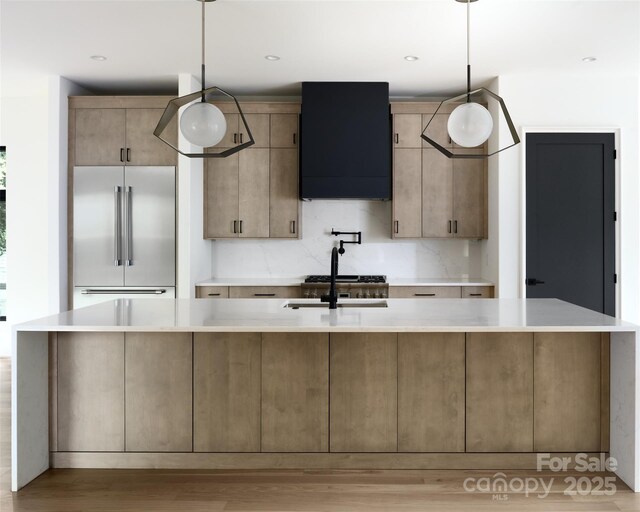 1511 Waverly Ave, Charlotte, NC 28203 - kitchen with stainless steel built in fridge, exhaust hood, light countertops, light wood-style flooring, and decorative light fixtures