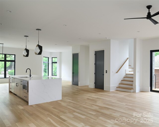 1511 Waverly Ave, Charlotte, NC 28203 - kitchen with open floor plan, light wood finished floors, a kitchen island with sink, and hanging light fixtures