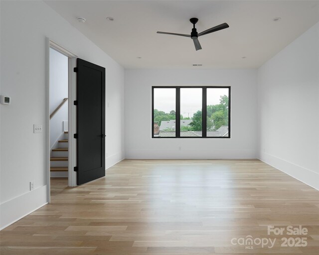 1511 Waverly Ave, Charlotte, NC 28203 - empty room with a ceiling fan, light wood finished floors, and stairway