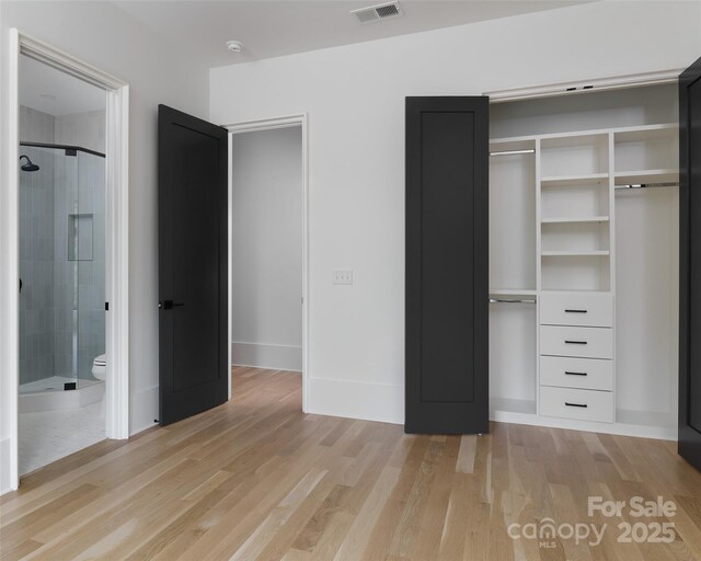 1511 Waverly Ave, Charlotte, NC 28203 - unfurnished bedroom with light wood finished floors, a closet, and ensuite bath
