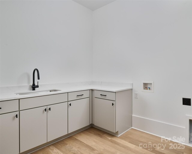 1511 Waverly Ave, Charlotte, NC 28203 - laundry area with washer hookup, light wood-type flooring, and cabinet space