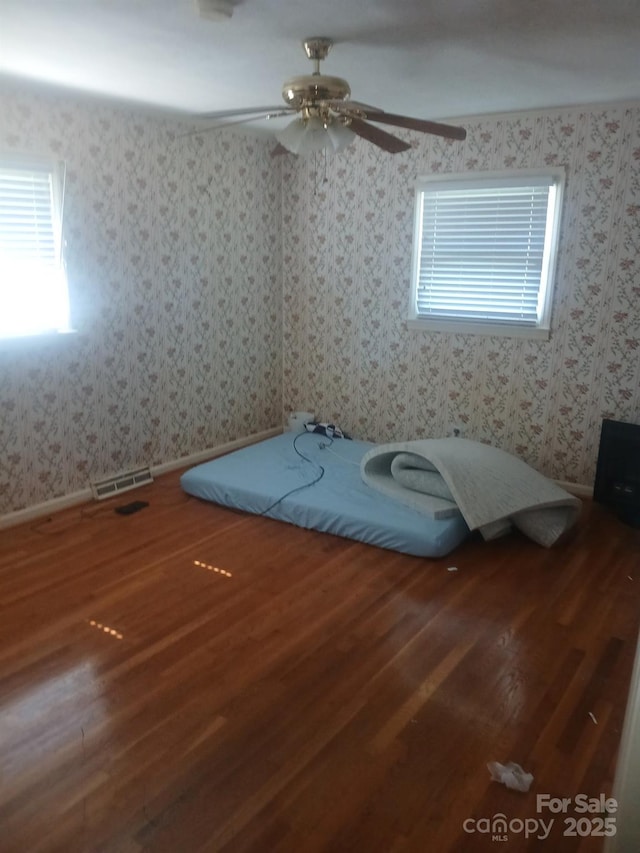 2815 Highland Dr, Lincolnton, NC 28092 - unfurnished bedroom featuring wood finished floors, wallpapered walls, and a ceiling fan
