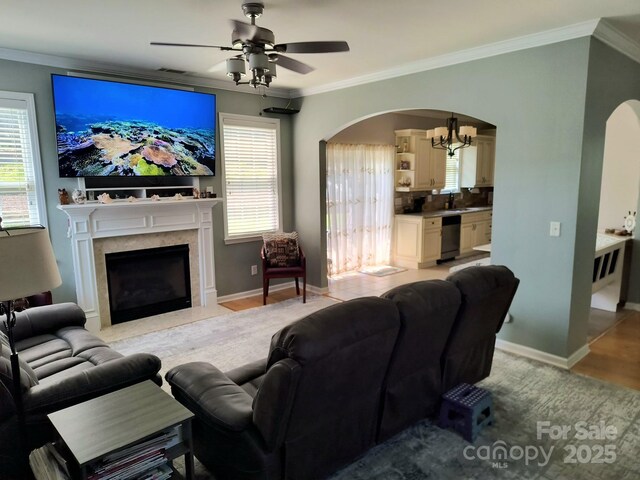 10825 Traders Ct, Davidson, NC 28036 - living area with arched walkways, crown molding, a fireplace, ceiling fan, and a chandelier