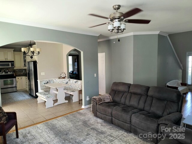 10825 Traders Ct, Davidson, NC 28036 - living area featuring a chandelier, arched walkways, a ceiling fan, crown molding, and light tile patterned flooring