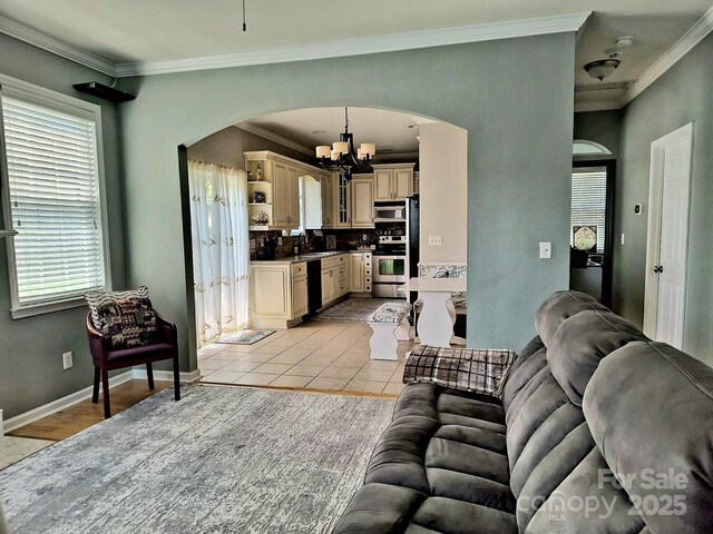 10825 Traders Ct, Davidson, NC 28036 - living room featuring a chandelier, arched walkways, ornamental molding, and light tile patterned floors