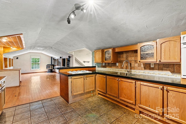 3724 County Home Rd, Conover, NC 28613 - kitchen featuring vaulted ceiling, dark countertops, glass insert cabinets, a peninsula, and open floor plan