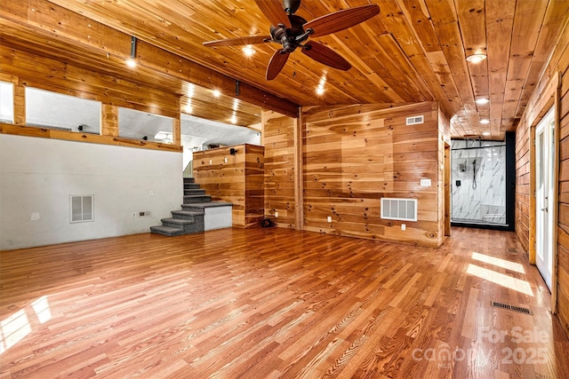 3724 County Home Rd, Conover, NC 28613 - unfurnished living room featuring wooden ceiling, ceiling fan, wood finished floors, stairway, and wood walls