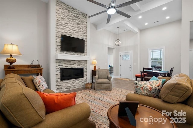 4210 Holly Cir NE, Conover, NC 28613 - living area featuring wood finished floors, beamed ceiling, ceiling fan, a stone fireplace, and a high ceiling