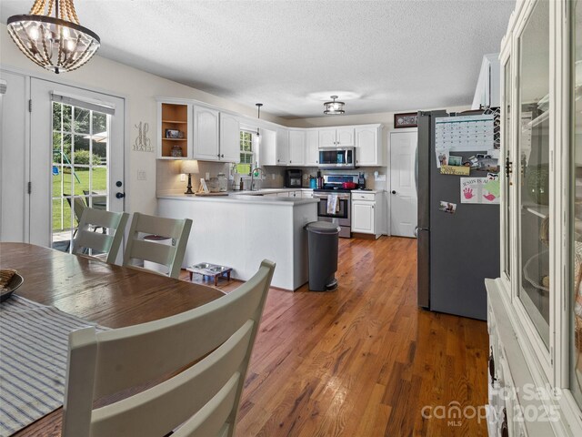3906 Brickfield St, Hickory, NC 28602 - dining room featuring wood finished floors, a textured ceiling, and a chandelier