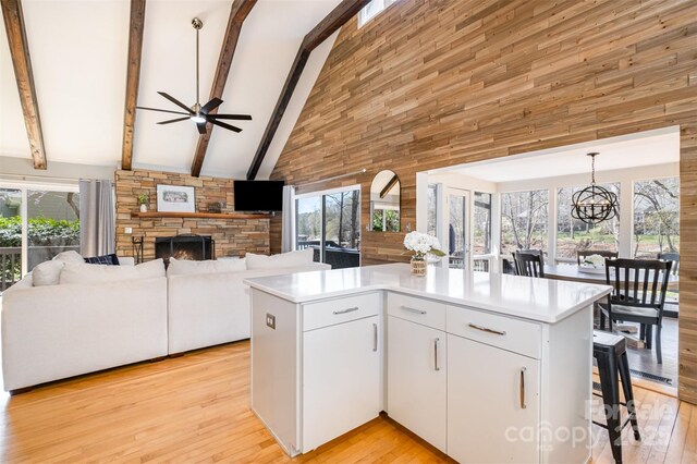 353 Whippoorwill Rd, Mooresville, NC 28117 - kitchen with high vaulted ceiling, a stone fireplace, open floor plan, light countertops, and beam ceiling