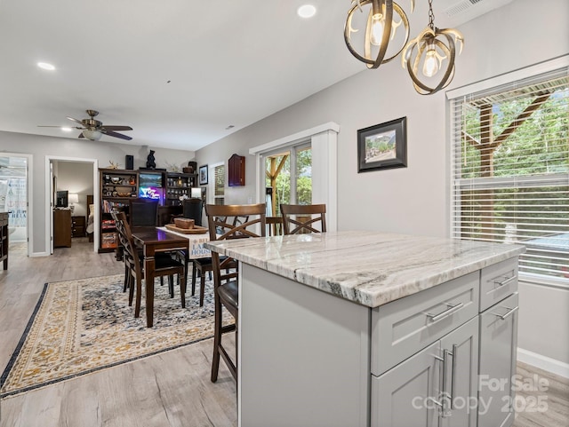 714 Bolt Rd, Lake Lure, NC 28746 - kitchen with light wood-style flooring, ceiling fan, a chandelier, light stone countertops, and a kitchen island