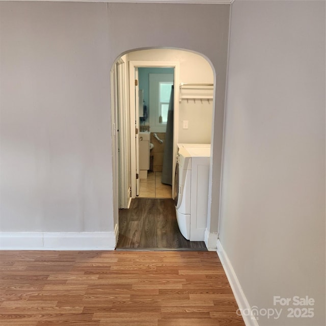 703/705 Smith St, Kannapolis, NC 28083 - hallway featuring washer and clothes dryer, wood finished floors, and arched walkways