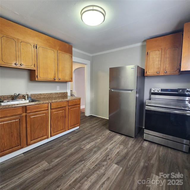 703/705 Smith St, Kannapolis, NC 28083 - kitchen with stainless steel appliances, ornamental molding, dark wood-type flooring, arched walkways, and brown cabinetry