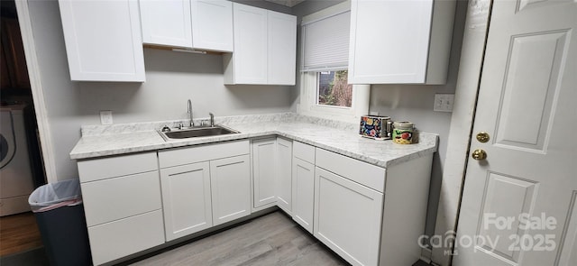 703/705 Smith St, Kannapolis, NC 28083 - kitchen featuring white cabinetry, light wood finished floors, and washer / dryer