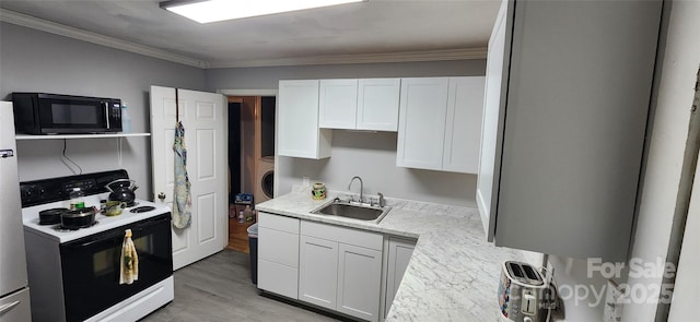 703/705 Smith St, Kannapolis, NC 28083 - kitchen with white electric range, black microwave, washer / dryer, white cabinets, and light wood-type flooring