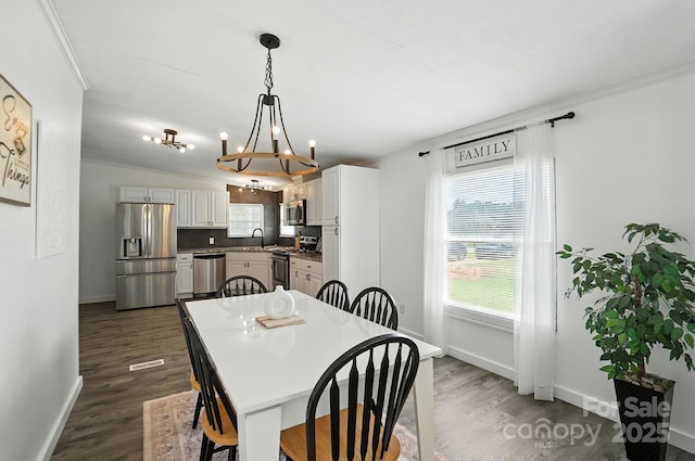 1778 N Ingleside Farm Rd, Iron Station, NC 28080 - dining room with a chandelier, dark wood-type flooring, and crown molding