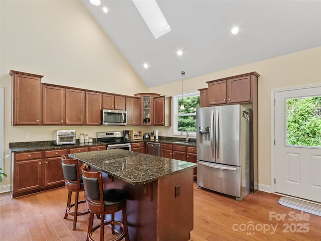 222 Fox Creek Rd, Mars Hill, NC 28754 - kitchen with appliances with stainless steel finishes, a skylight, light wood finished floors, a kitchen island, and high vaulted ceiling