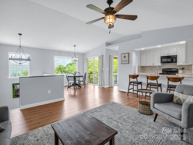 198 Sugarbush Pt, Lake Lure, NC 28746 - living area with wood finished floors, vaulted ceiling, a chandelier, and a ceiling fan