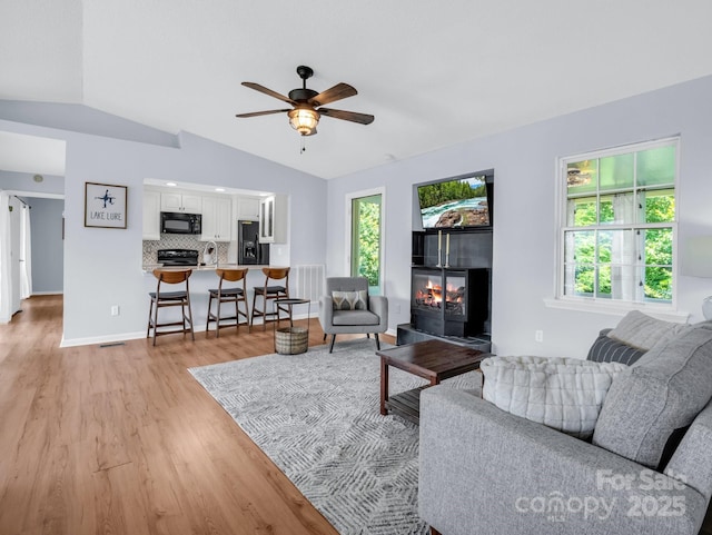 198 Sugarbush Pt, Lake Lure, NC 28746 - living area featuring vaulted ceiling, light wood finished floors, a ceiling fan, and a fireplace