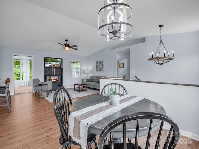 198 Sugarbush Pt, Lake Lure, NC 28746 - dining space with a chandelier, light wood-type flooring, a tile fireplace, ceiling fan, and lofted ceiling