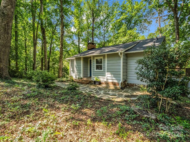 1463 Carolina Dr, Tryon, NC 28782 - view of side of home with a chimney and a patio area