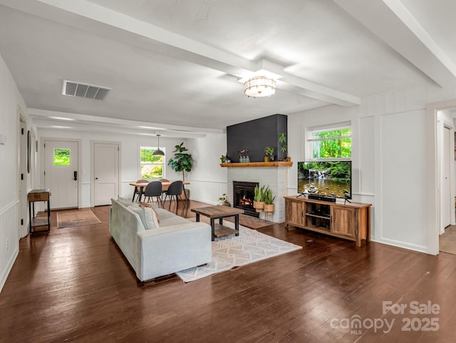 1463 Carolina Dr, Tryon, NC 28782 - living area with a decorative wall, dark wood-style flooring, a brick fireplace, and beam ceiling