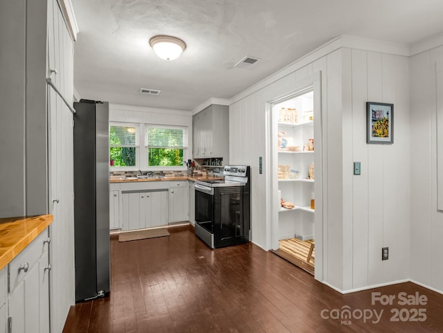 1463 Carolina Dr, Tryon, NC 28782 - kitchen with appliances with stainless steel finishes, dark wood-style floors, butcher block countertops, and ornamental molding