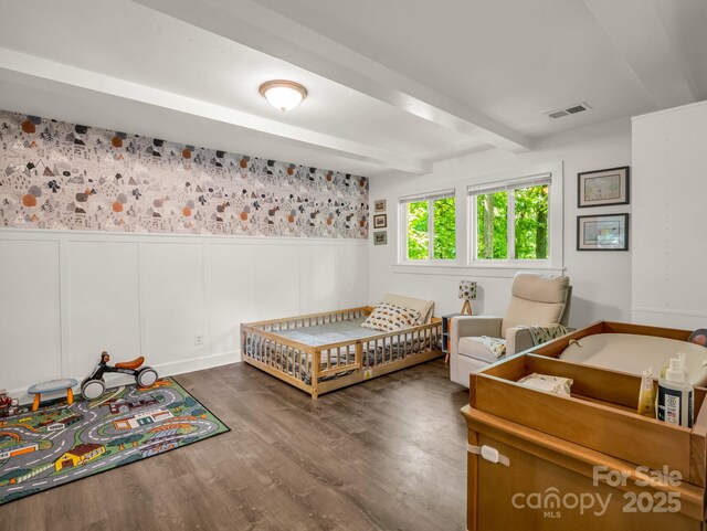 1463 Carolina Dr, Tryon, NC 28782 - bedroom with beamed ceiling, a wainscoted wall, wood finished floors, and a decorative wall