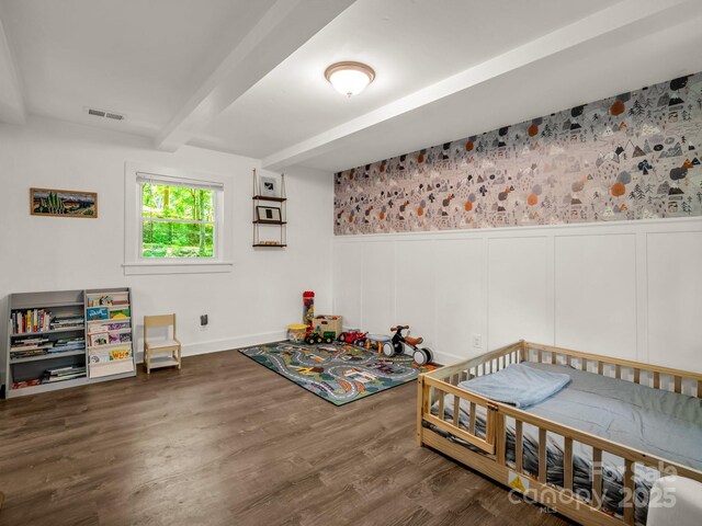 1463 Carolina Dr, Tryon, NC 28782 - bedroom featuring beam ceiling, wood finished floors, a wainscoted wall, and a decorative wall
