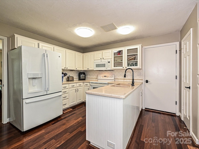 2621 Brightmoor Ridge Dr, Matthews, NC 28105 - kitchen featuring white appliances, a peninsula, dark wood-type flooring, glass insert cabinets, and a textured ceiling