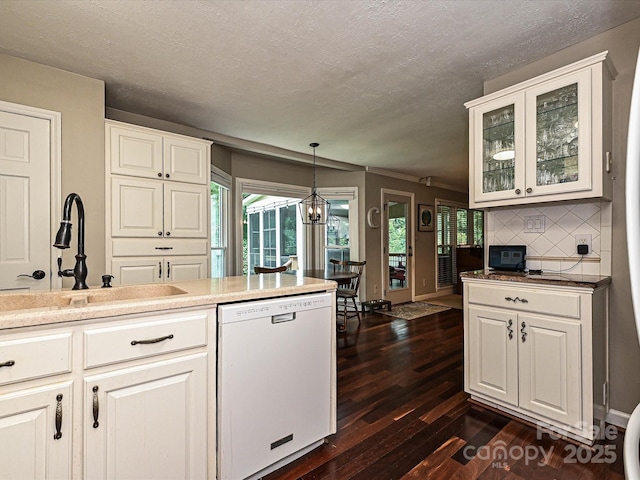 2621 Brightmoor Ridge Dr, Matthews, NC 28105 - kitchen with white dishwasher, dark wood finished floors, a textured ceiling, glass insert cabinets, and decorative backsplash