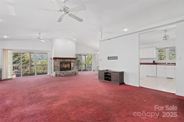 371 Clearview Dr, Waynesville, NC 28786 - unfurnished living room with light carpet, vaulted ceiling, a ceiling fan, recessed lighting, and a fireplace