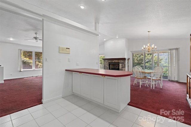 371 Clearview Dr, Waynesville, NC 28786 - kitchen with light carpet, a peninsula, a stone fireplace, recessed lighting, and a ceiling fan