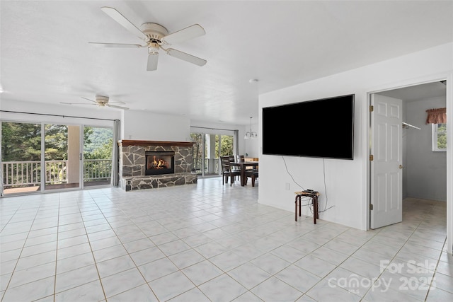 371 Clearview Dr, Waynesville, NC 28786 - unfurnished living room featuring a fireplace, light tile patterned floors, ceiling fan, and healthy amount of natural light