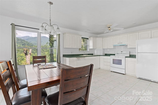 371 Clearview Dr, Waynesville, NC 28786 - kitchen with white appliances, a chandelier, decorative backsplash, and dark countertops