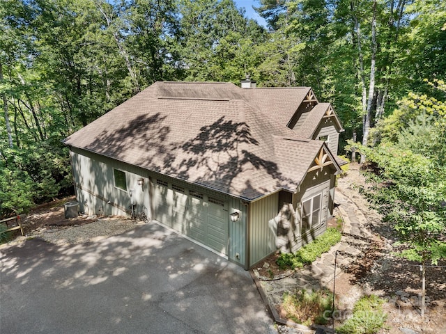 3094 Connestee Trl, Brevard, NC 28712 - rustic home featuring a shingled roof, driveway, a garage, and a chimney