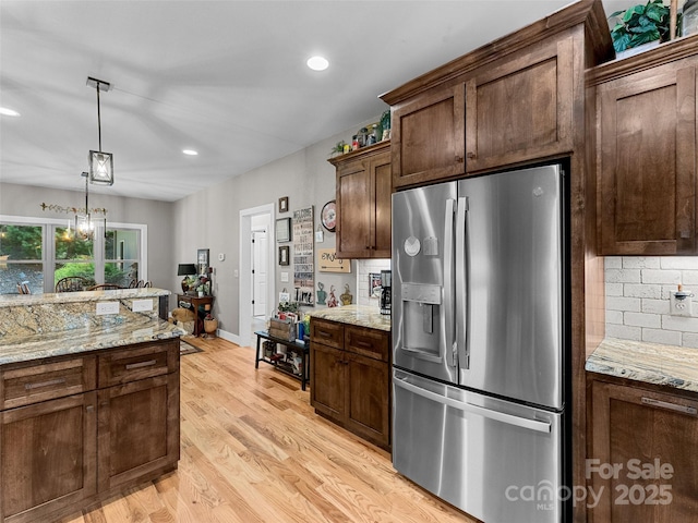3094 Connestee Trl, Brevard, NC 28712 - kitchen featuring stainless steel refrigerator with ice dispenser, backsplash, decorative light fixtures, light wood-type flooring, and recessed lighting