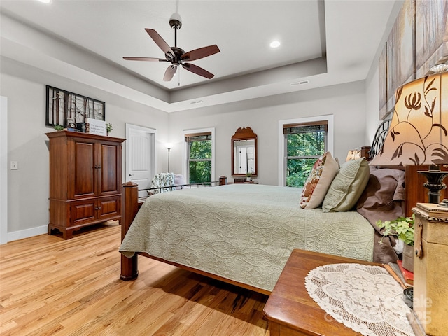 3094 Connestee Trl, Brevard, NC 28712 - bedroom featuring light wood-style floors, a tray ceiling, recessed lighting, and ceiling fan