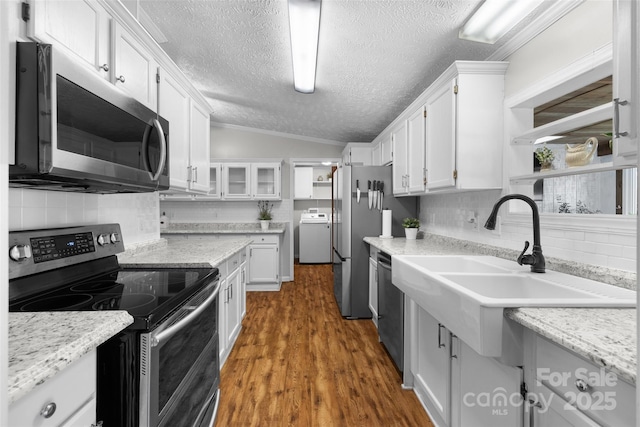 4534 Pebblebrook Cir SW, Concord, NC 28027 - kitchen with appliances with stainless steel finishes, open shelves, white cabinetry, washer / clothes dryer, and a textured ceiling