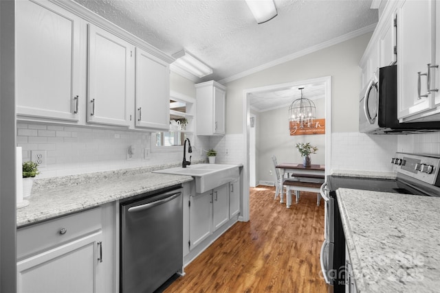 4534 Pebblebrook Cir SW, Concord, NC 28027 - kitchen with stainless steel appliances, tasteful backsplash, crown molding, wood finished floors, and a textured ceiling
