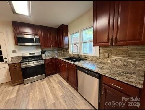 148 Barium Ln, Statesville, NC 28677 - kitchen with stainless steel appliances, light wood-type flooring, backsplash, and light stone counters