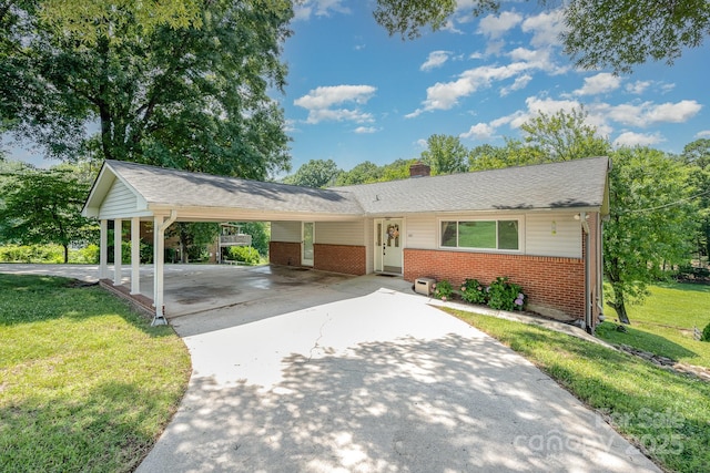 301 Rosemont Ave SE, Concord, NC 28025 - ranch-style house with brick siding, a front yard, driveway, an attached carport, and a chimney