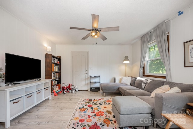 301 Rosemont Ave SE, Concord, NC 28025 - living area featuring light wood-style floors, a ceiling fan, a textured ceiling, and a decorative wall