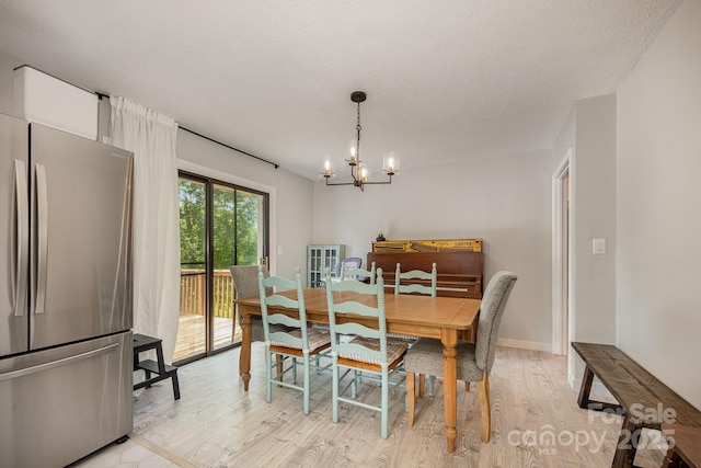 301 Rosemont Ave SE, Concord, NC 28025 - dining space featuring a chandelier, light wood-type flooring, and a textured ceiling