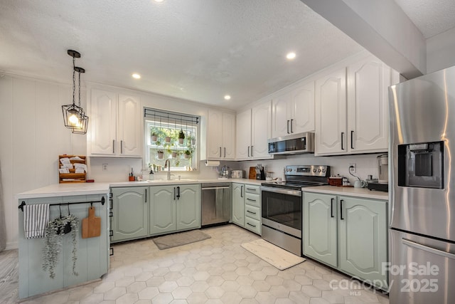 301 Rosemont Ave SE, Concord, NC 28025 - kitchen featuring stainless steel appliances, light countertops, green cabinets, decorative light fixtures, and a textured ceiling