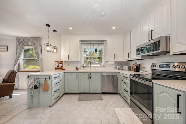 301 Rosemont Ave SE, Concord, NC 28025 - kitchen featuring stainless steel appliances, a peninsula, light countertops, a textured ceiling, and white cabinetry